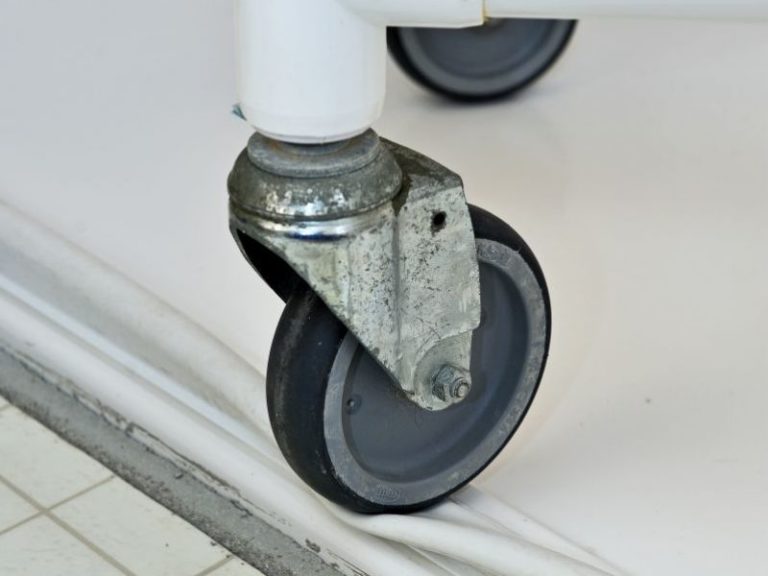 Collapsible dam height for roll-in shower
